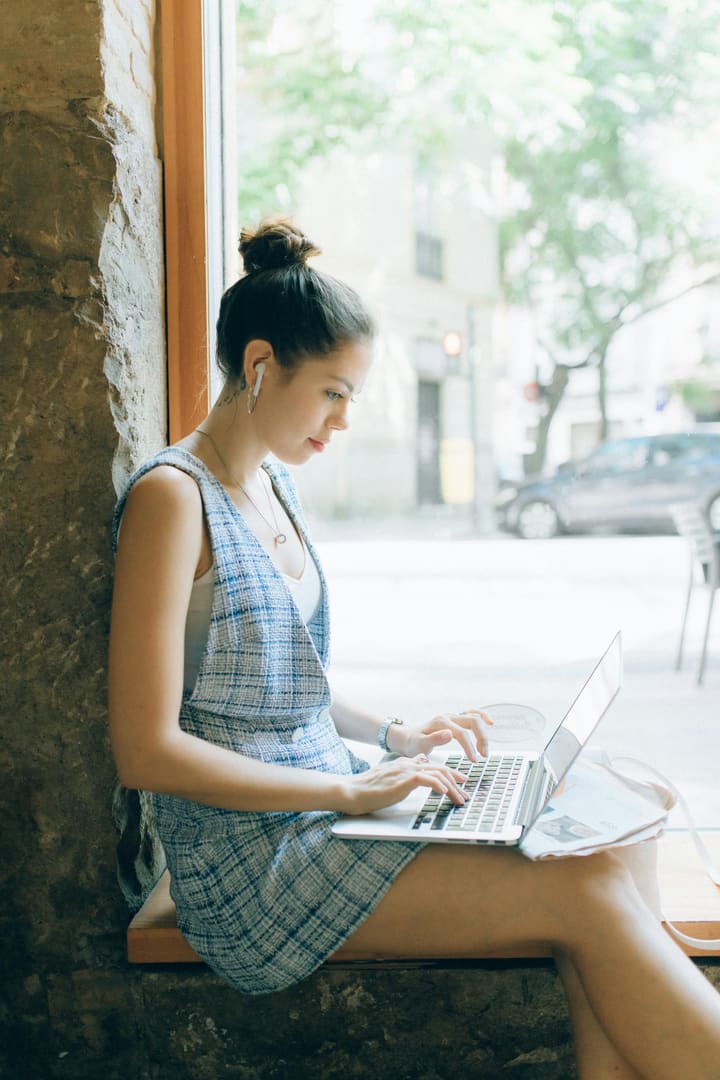 Persona física trabajando en laptop desde un café